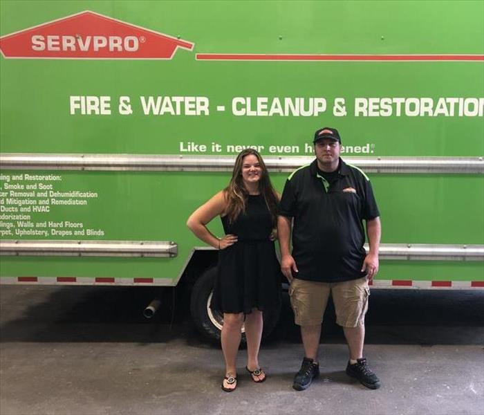 two people in front of SERVPRO truck